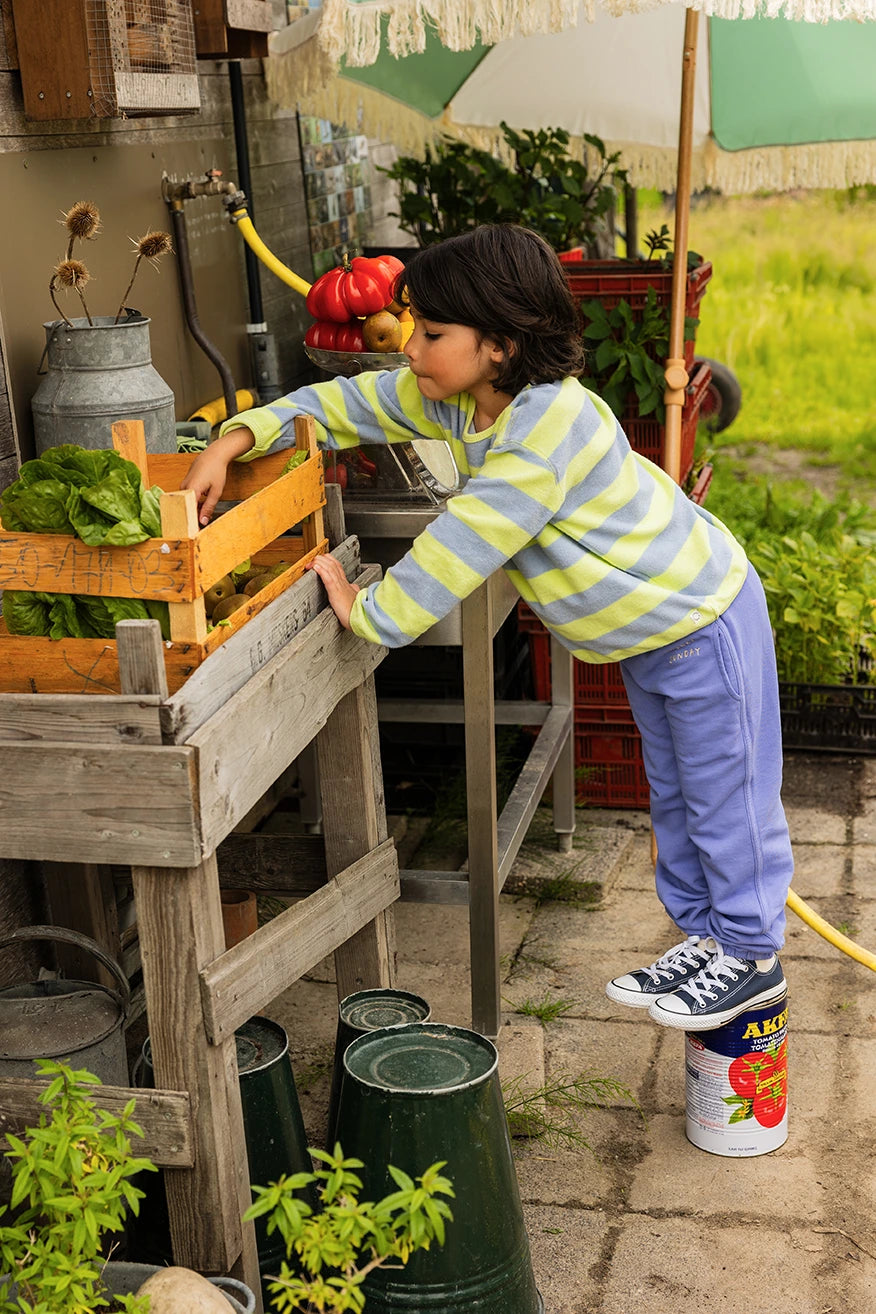 Jongen met een Sproet & Sprout Sweatshirt Terry Stripes aan in de tuin