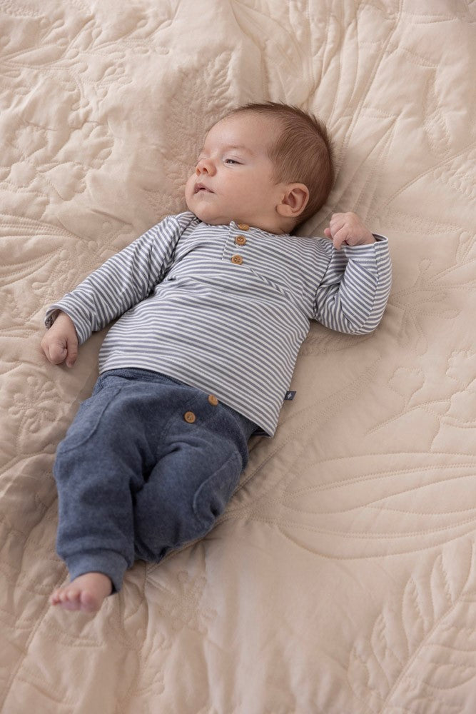 Baby met een Feetje Broek Farm Life thema met zakken op de zijde