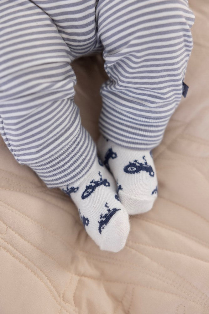 Baby met een Feetje Broek Streep Farm Life thema aan en sokken